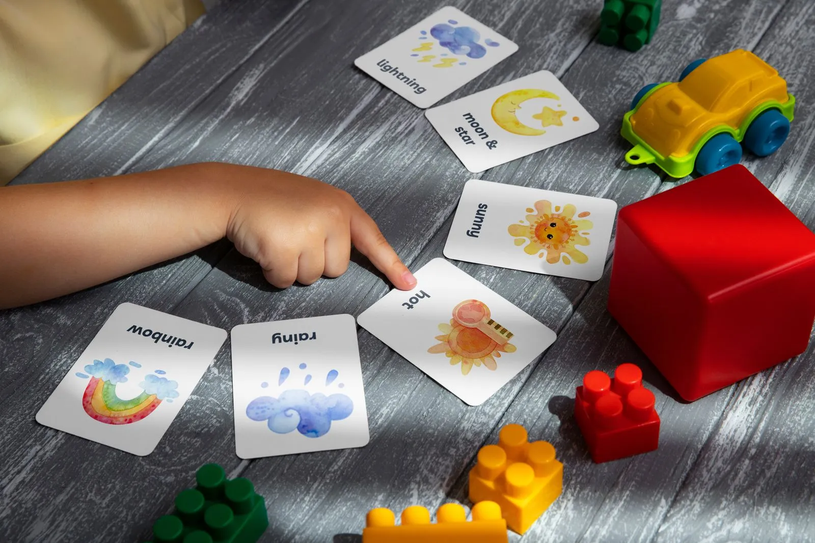 Criança apontando para cartas ilustradas
